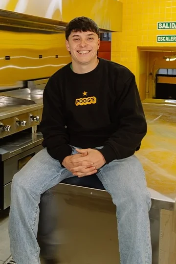 Alejo, dueño de Pogg's, sentado en la mesada de su cocina