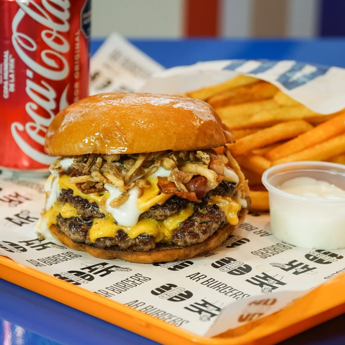 Hamburguesa con cheddar y cebolla crocante sobre pan Olympus Buns